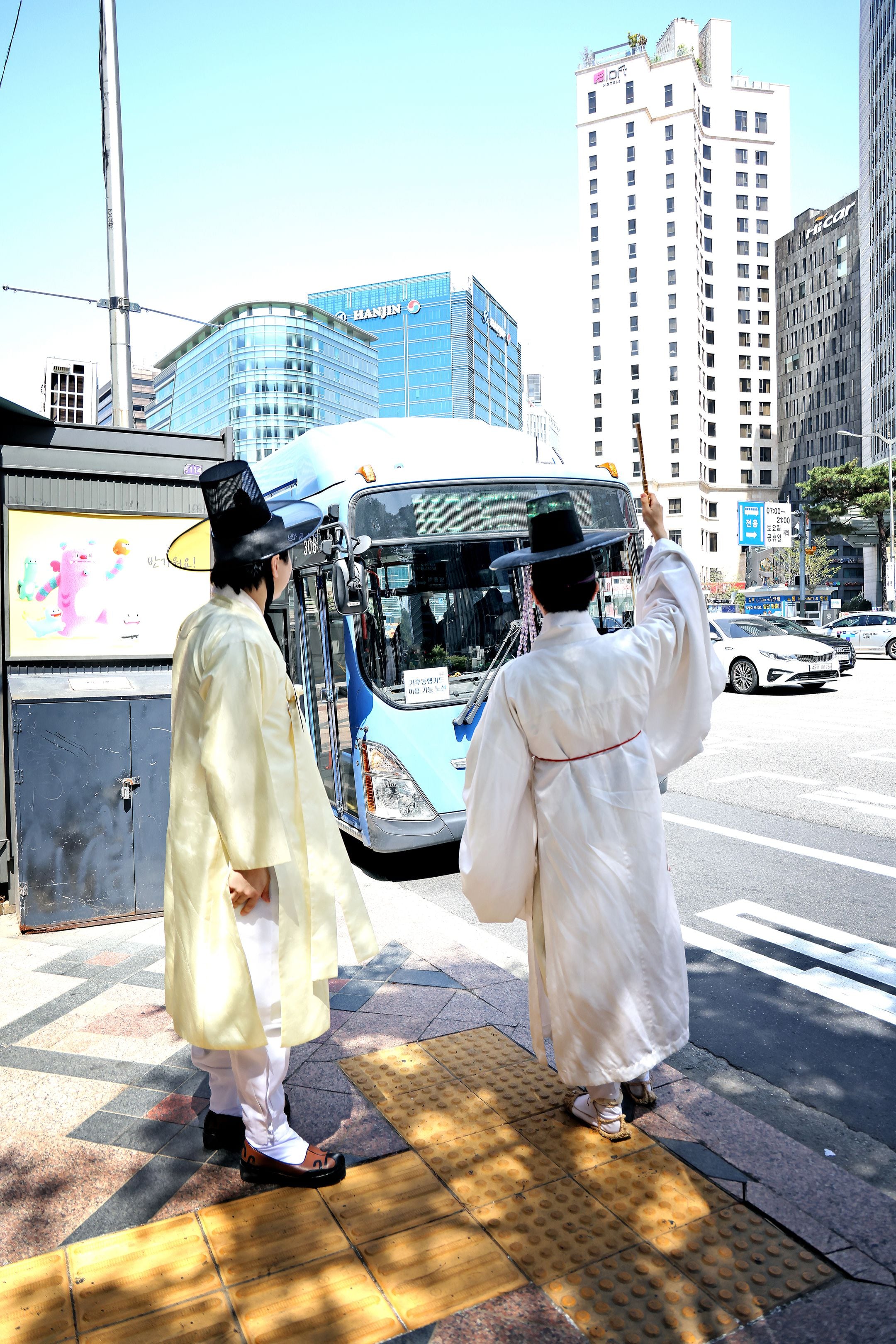 지난 13일 서울 중구의 한 버스 정류장에서 송민근오른쪽씨가 손에 쥐고 있던 전통 부채를 들어 올려서 버스 탑승 의사를 표현하고 있다. /주민욱 영상미디어 기자